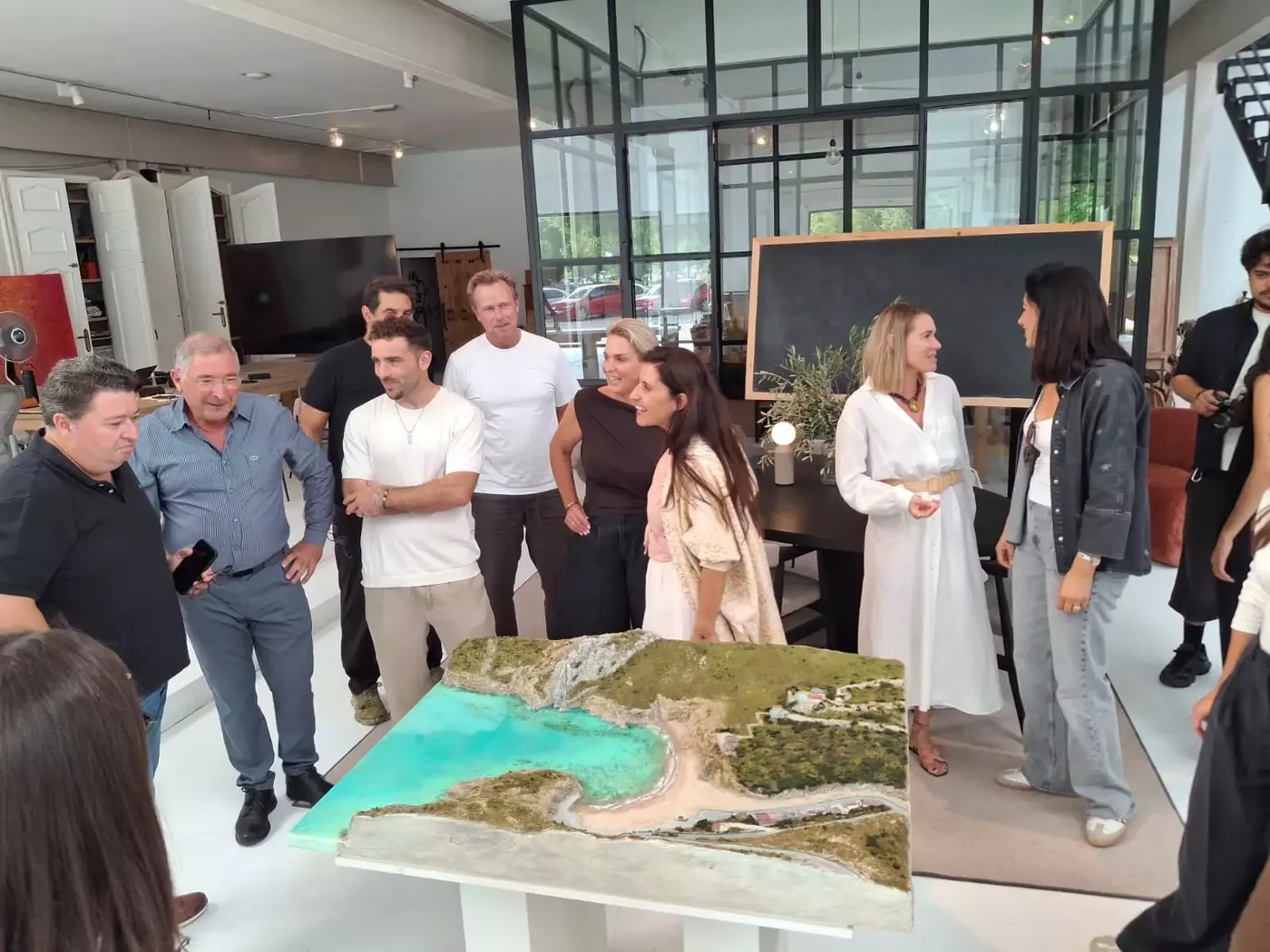 Guests and press gathered around the relief model of La Granadella cove at the Jessica Bataille Atelier